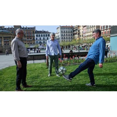 Enrique Martín Monreal, Patxi Iriguíbel y José Manuel Echeverría dan toques a un balón en la plaza del Castillo